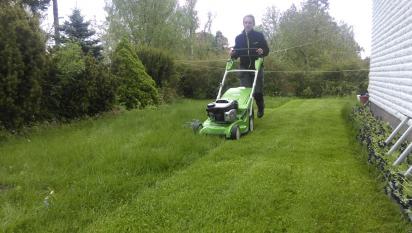 Camilla klipper gräset och rensar ogräs