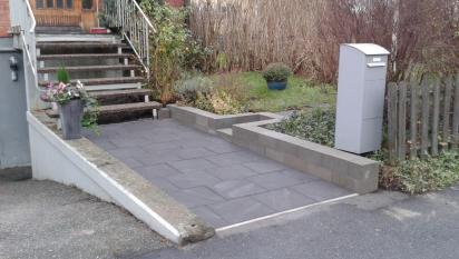 Plattsättning med betongblock Labyrint Maxi Skarp som rabattkant och för att ge lite stöd för den höjdskillnad som är mellan gräsmattan och gångytan.